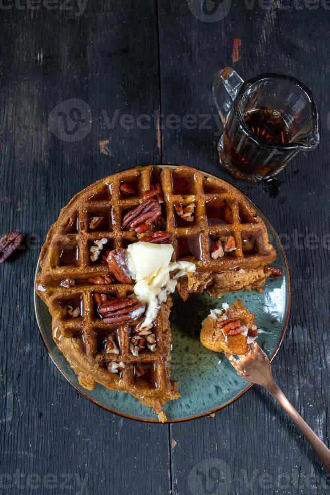 pumpkin waffles with pecans topped with butter and syrup flat lay photo