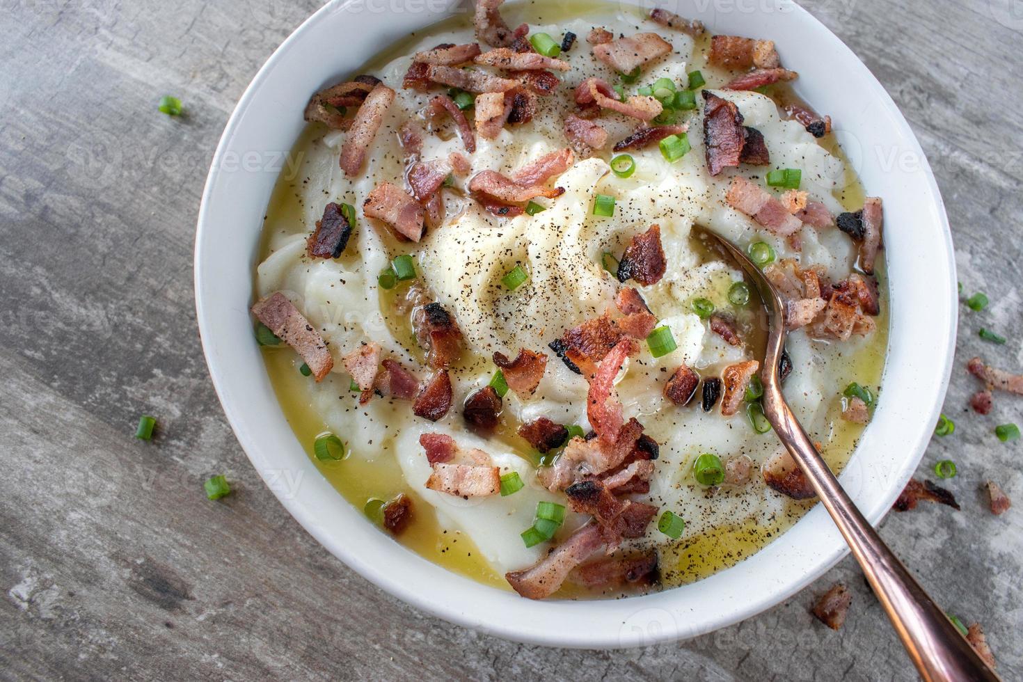 homemade bowl of mashed potatoes with bacon and green onions with butter flat lay photo