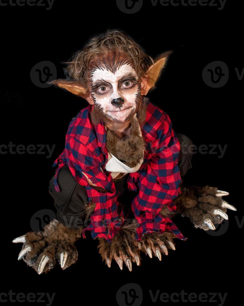 studio shot portrait of young boy in costume dressed as a Halloween, cosplay of scary werewolf pose on isolated black background photo