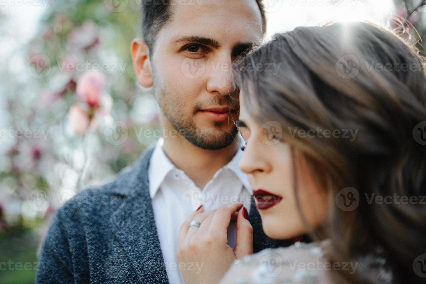 Sunshine portrait of happy bride and groom outdoor in nature location at sunset. Warm summertime photo