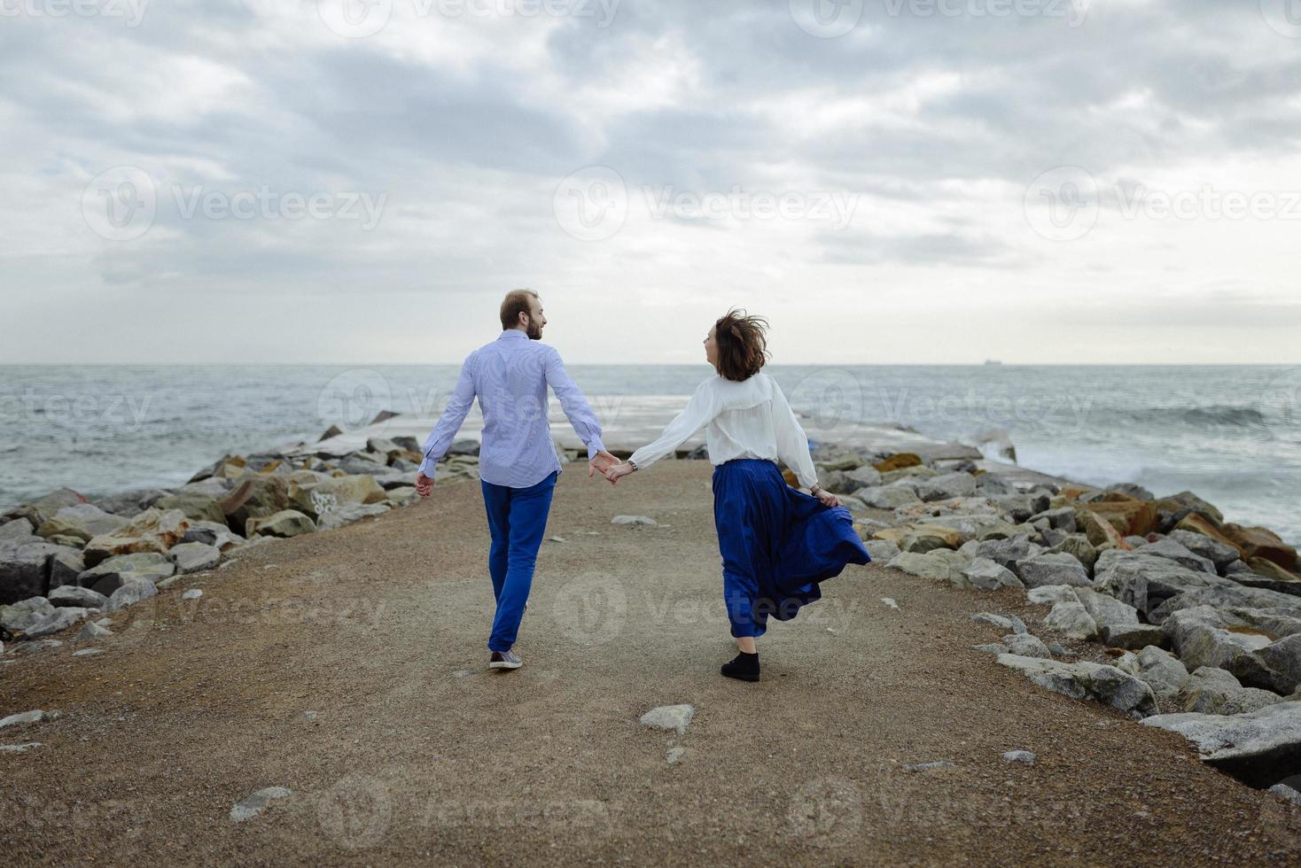 A loving couple, man and woman enjoying summer vacation on a tropical paradise beach with clear sea ocean water and scenic photo