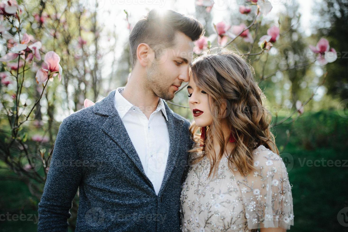 Sunshine portrait of happy bride and groom outdoor in nature location at sunset. Warm summertime photo