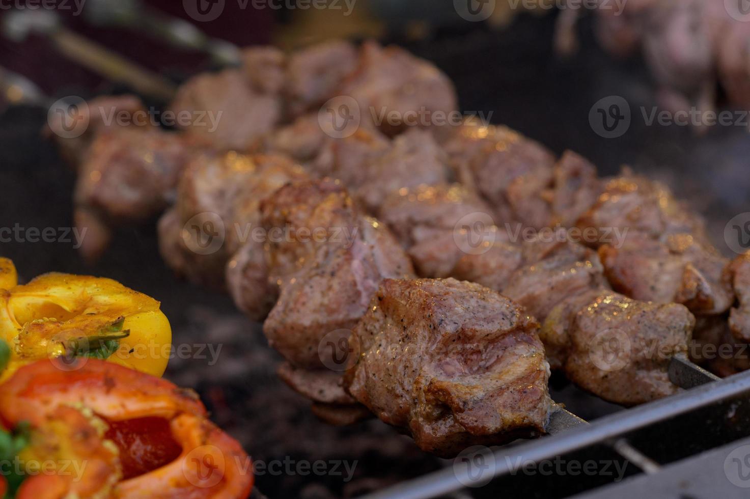 salchicha a la parrilla con la adición de hierbas y verduras en el plato de parrilla, al aire libre. comida a la parrilla, barbacoa, barbacoa foto