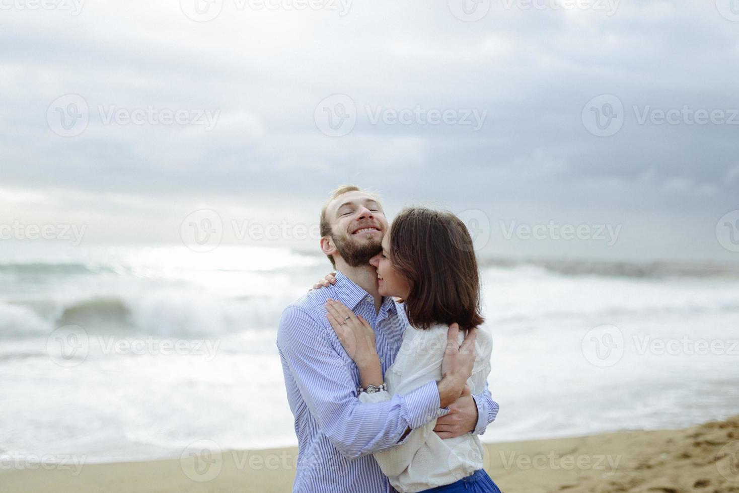 A loving couple, man and woman enjoying summer vacation on a tropical paradise beach with clear sea ocean water and scenic photo