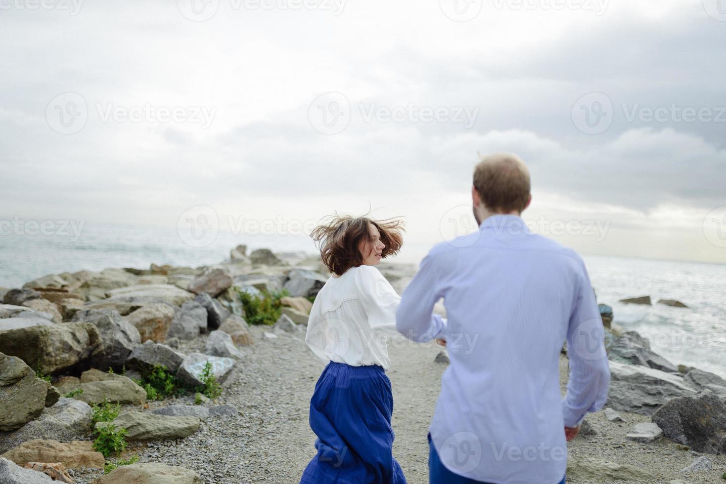 A loving couple, man and woman enjoying summer vacation on a tropical paradise beach with clear sea ocean water and scenic photo