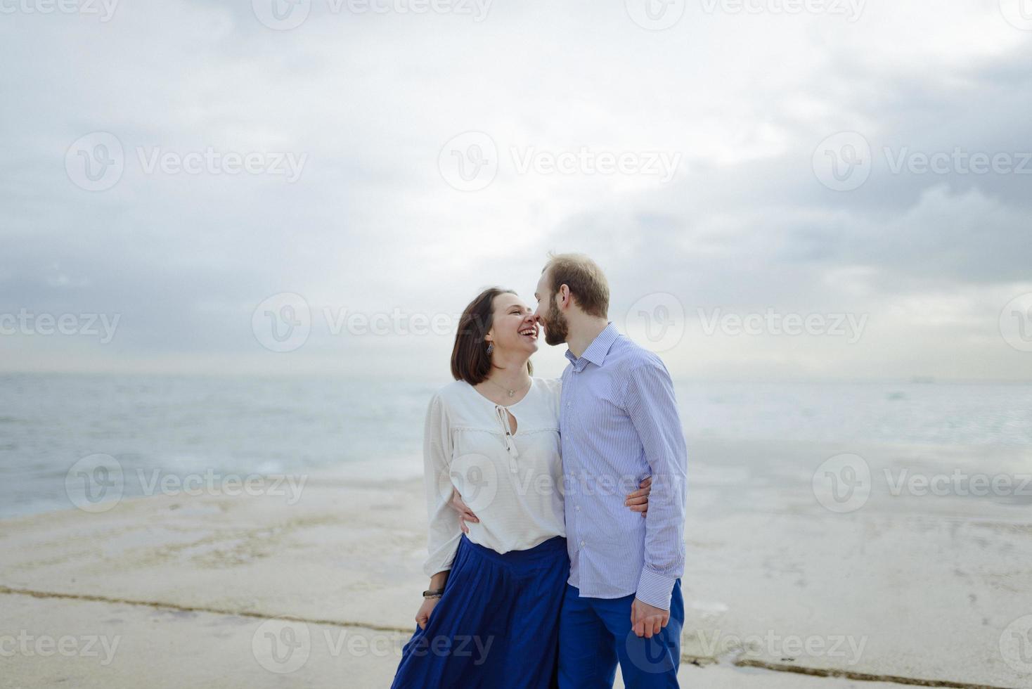 A loving couple, man and woman enjoying summer vacation on a tropical paradise beach with clear sea ocean water and scenic photo