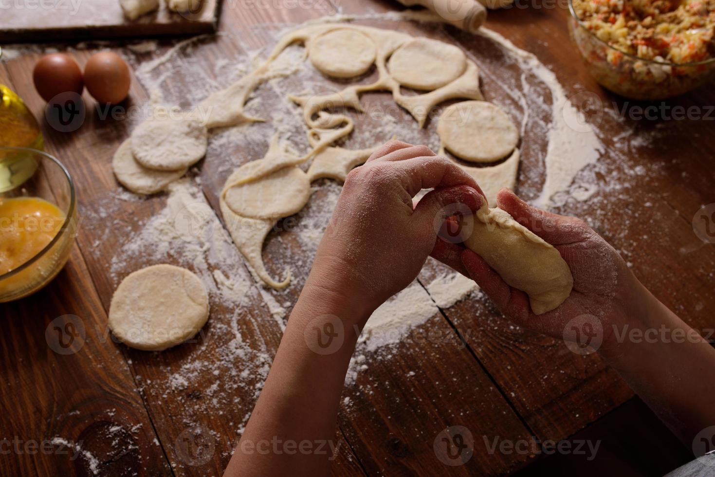 Raw homemade pies on a wooden background. photo