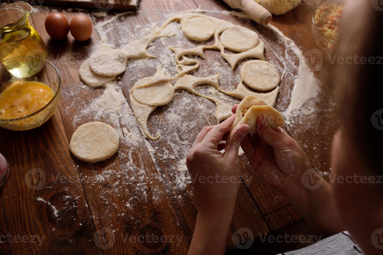 Raw homemade pies on a wooden background. photo