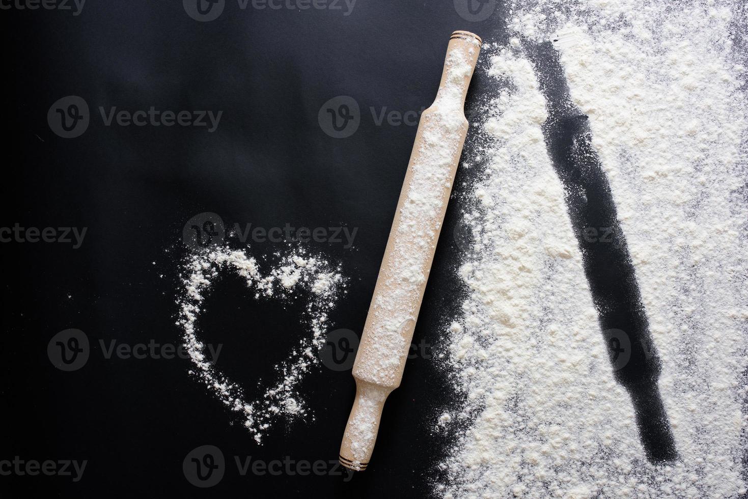 Abstract background. Sprinkled wheat flour circle, round spot on black. Top view on blackboard. Baking concept, cooking dough or pastry. photo