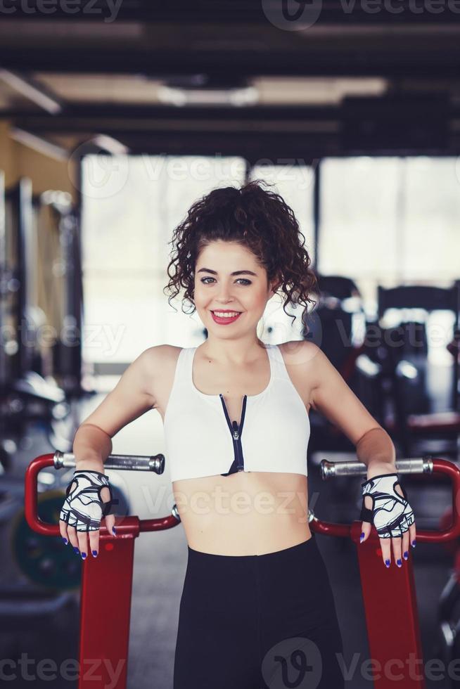 Curly young girl resting after dumbbells exercises photo