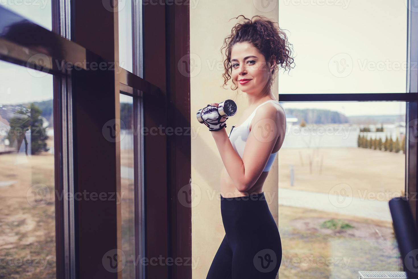 Strong fit woman exercising with dumbbell photo