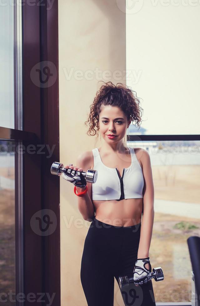 woman does the exercises with dumbbells photo