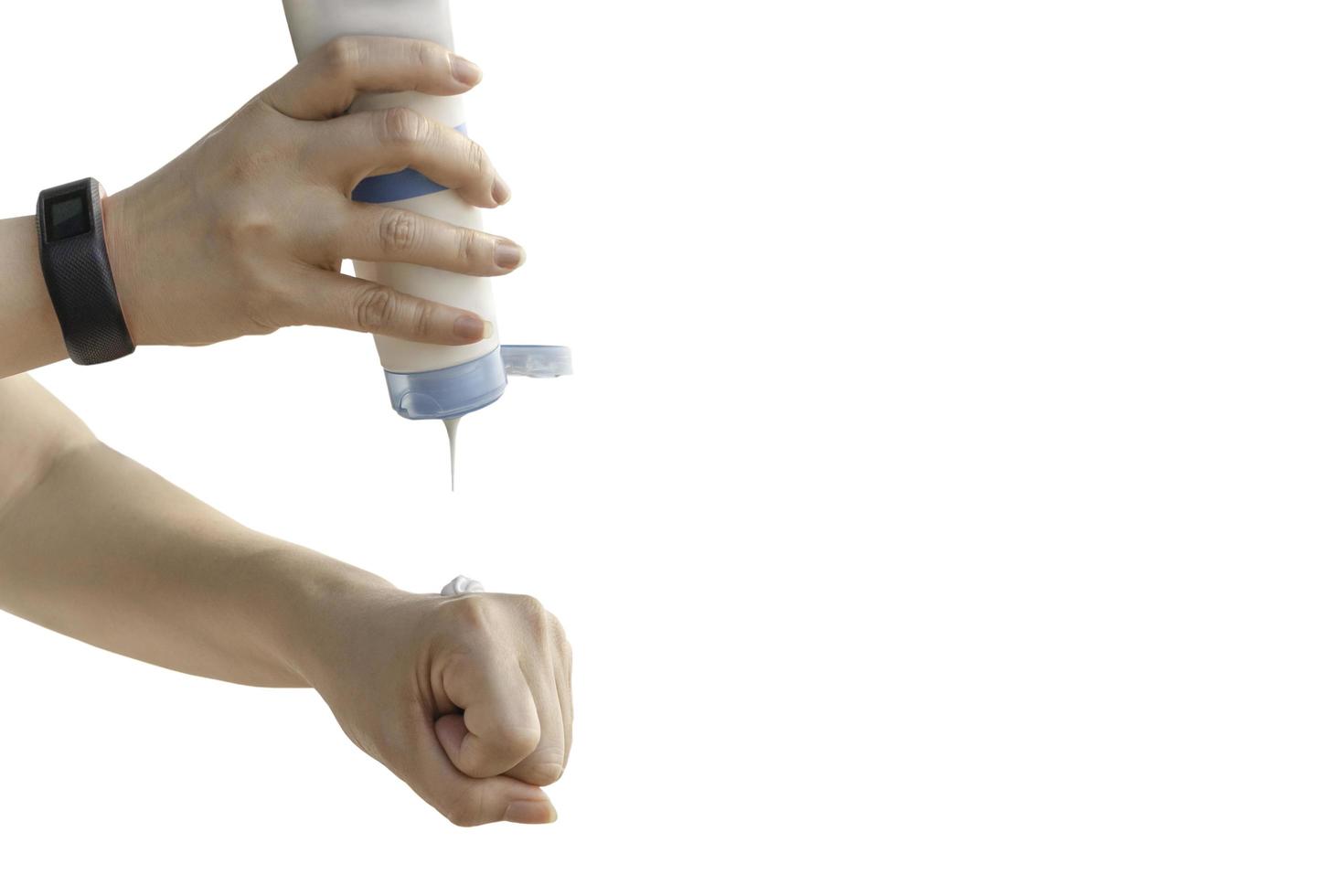 Woman pouring sun protection cream on her hand isolated in clipping path. photo