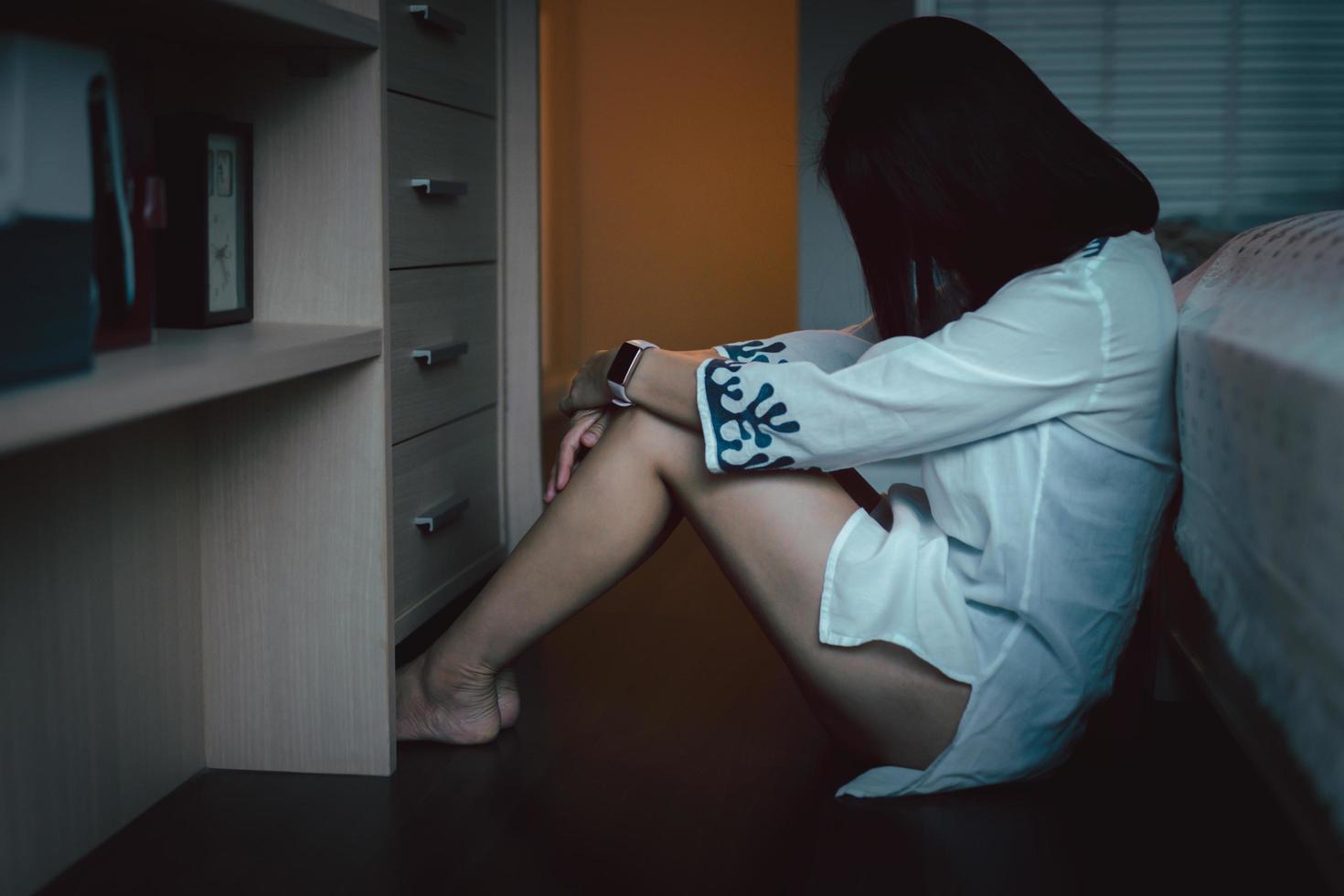 depressed woman sitting on floor in bedroom at home. photo