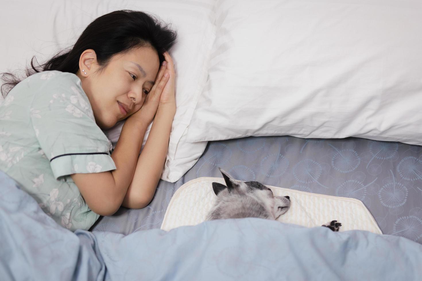 Happy smiling woman sleeping with a dog in bed at home. photo