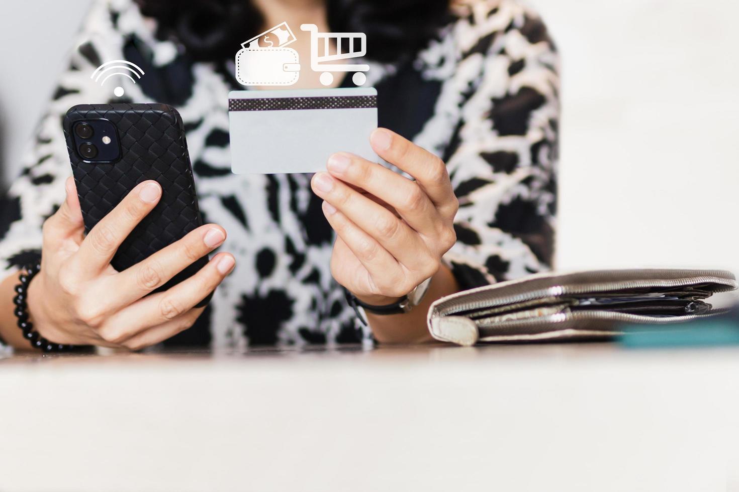 mujer sosteniendo teléfono celular y tarjeta de crédito, concepto de compras en línea. foto