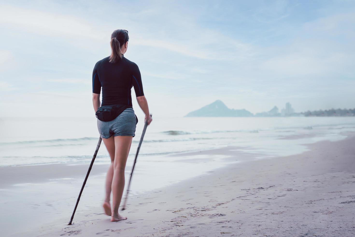 mujer de senderismo en el desenfoque de movimiento de la playa. estilo de vida activo y saludable. foto