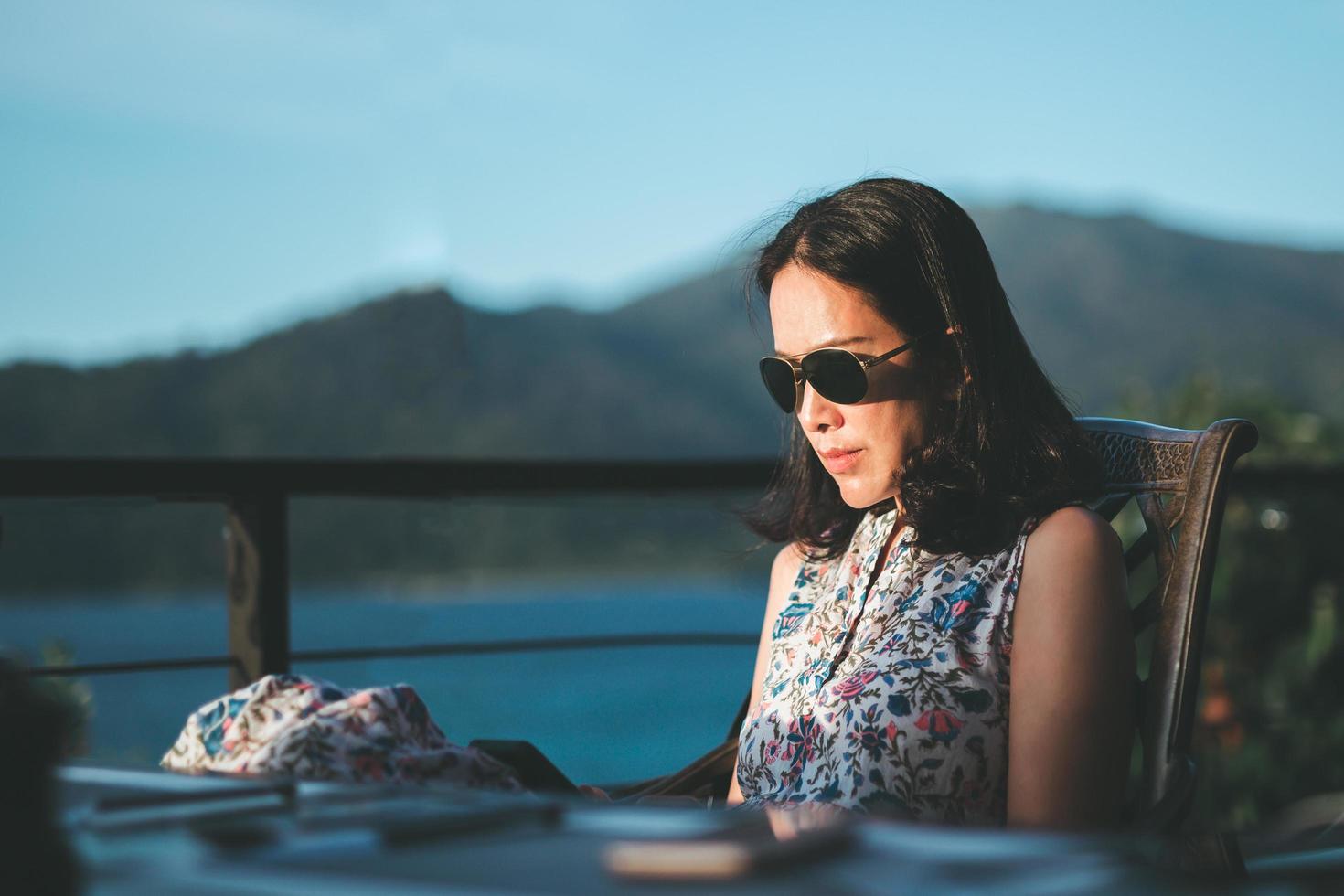 Woman with sunglasses using cell phone outdoor. photo