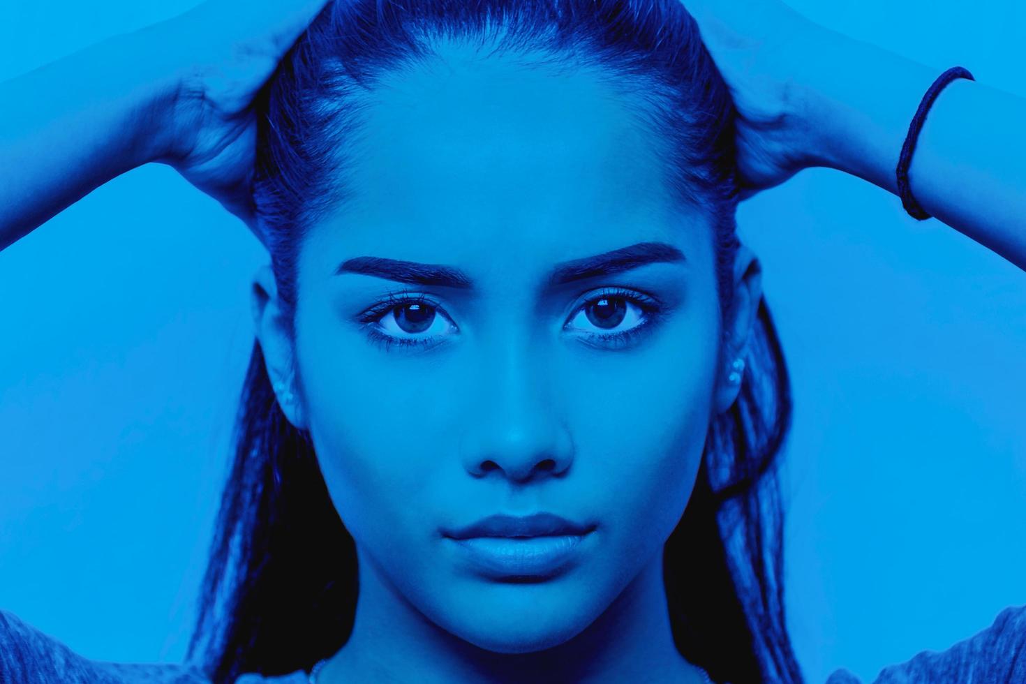 Portrait of young woman face in blue color. photo