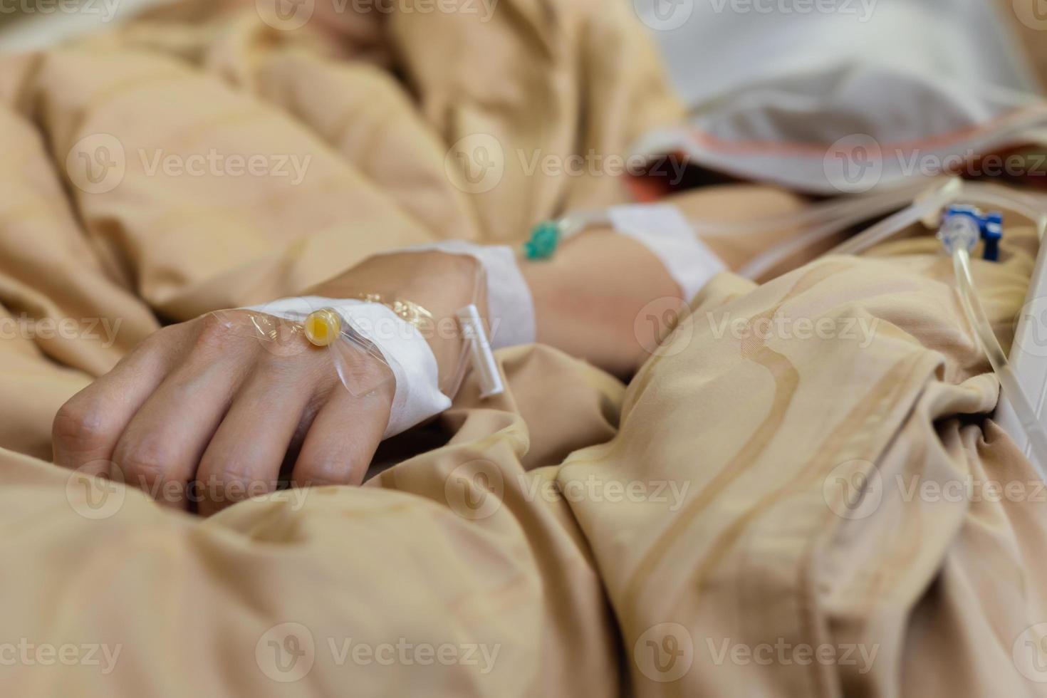 Focus on the hand of a patient lying in hospital ward. photo