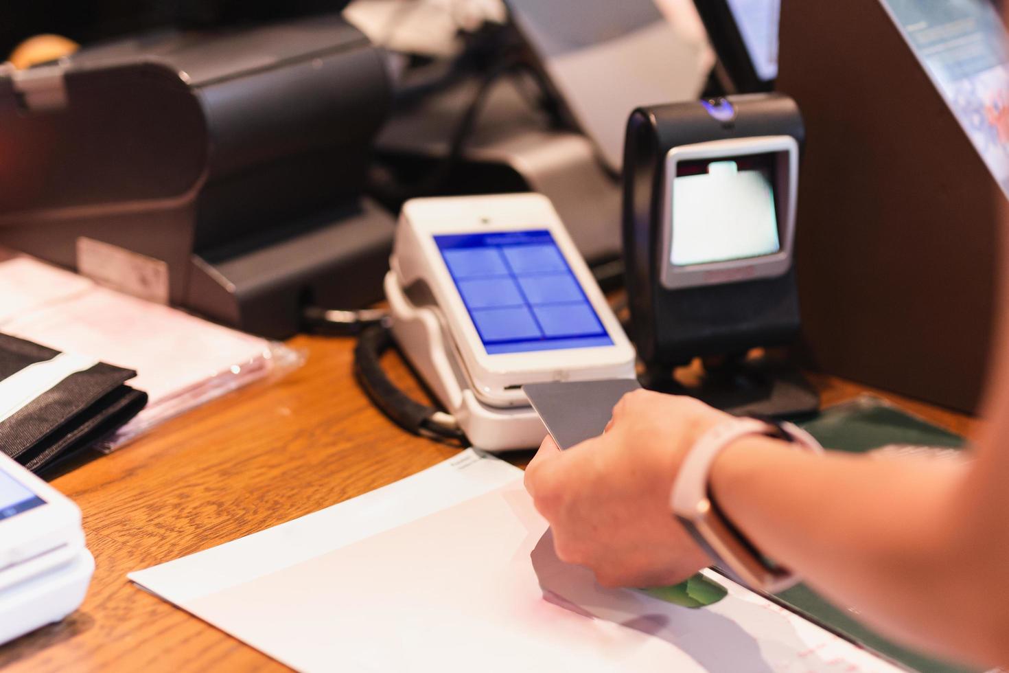 mujer pagando la cuenta en el café insertando la tarjeta de crédito en el lector de tarjetas de crédito. foto