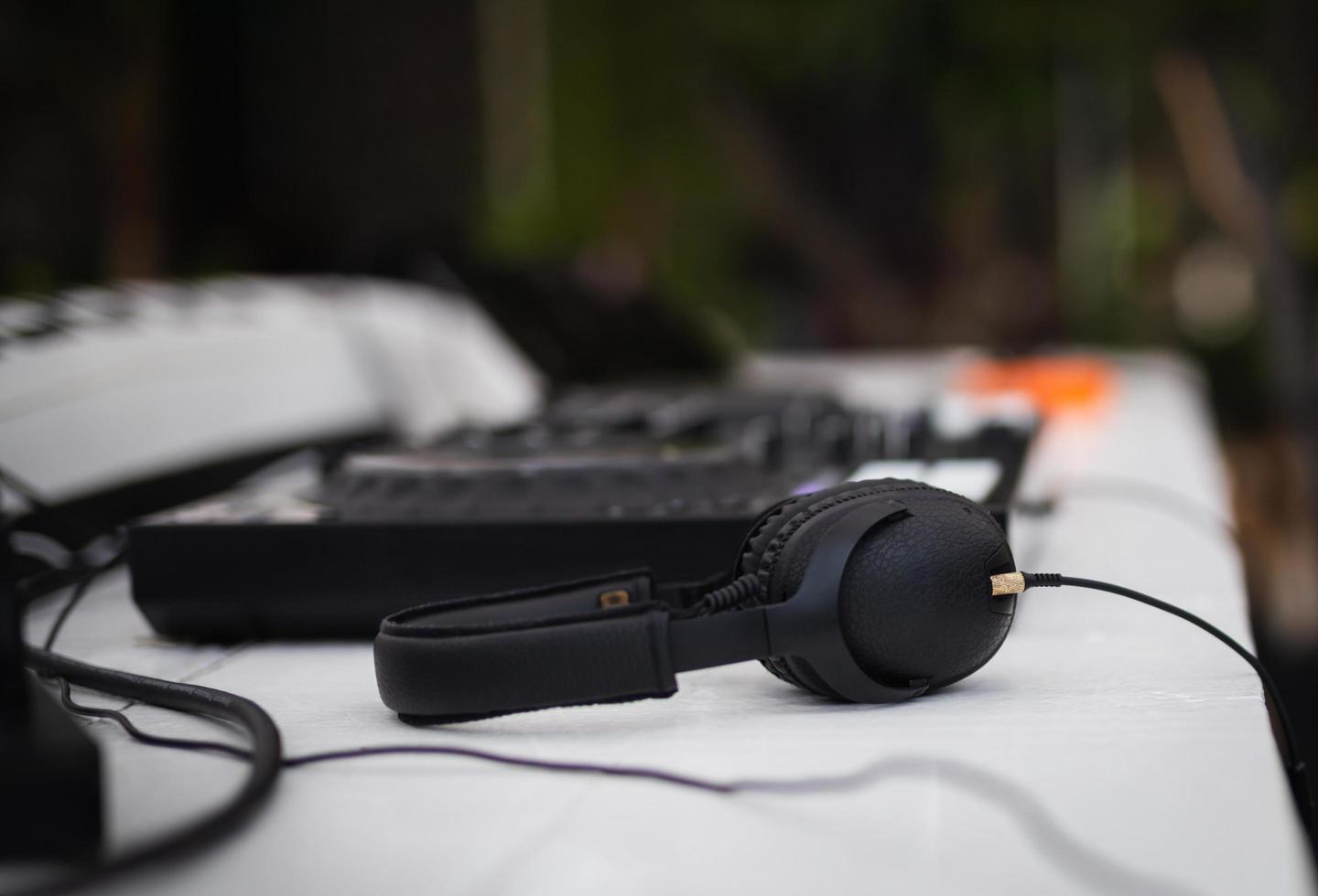 Black headphones and professional mixing console on table. photo