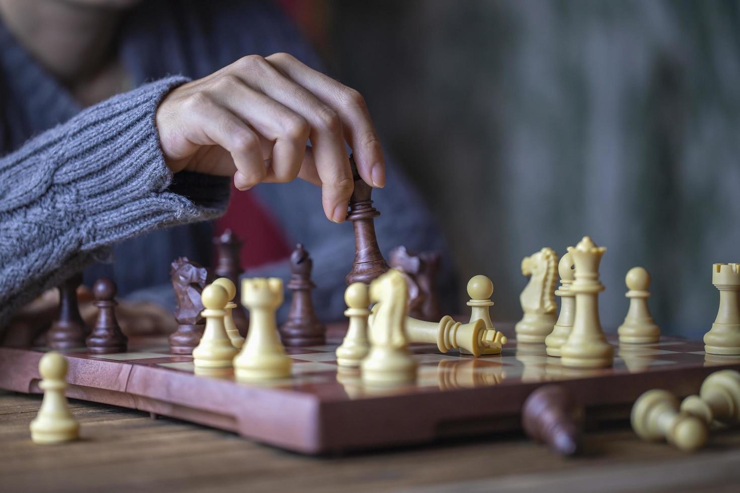 primer plano mano de mujer joven jugando ajedrez para el concepto de ganador de la competencia de desafío empresarial foto