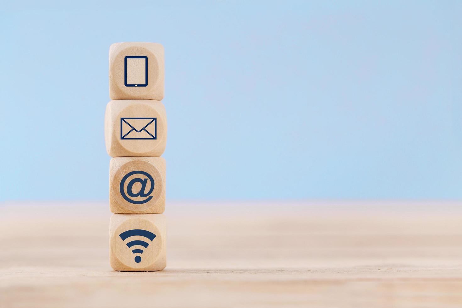 Close up Wooden block cube with communication symbol icon mobile phone, email, address and wifi on table photo