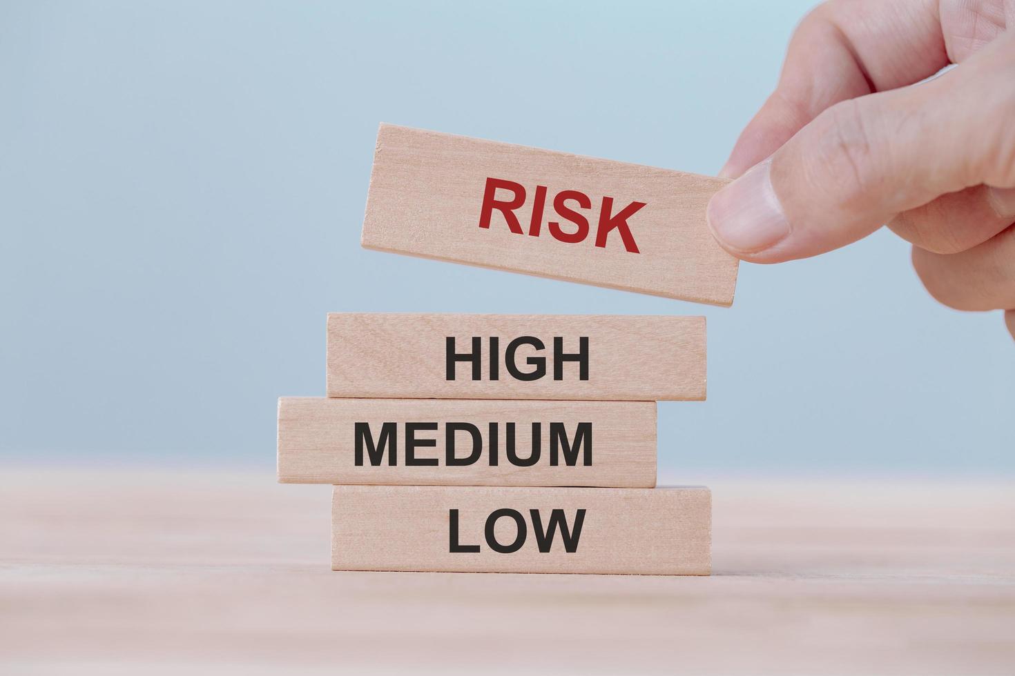 Hand holding chooses wooden block cubes with risk word. Risk management concept. photo