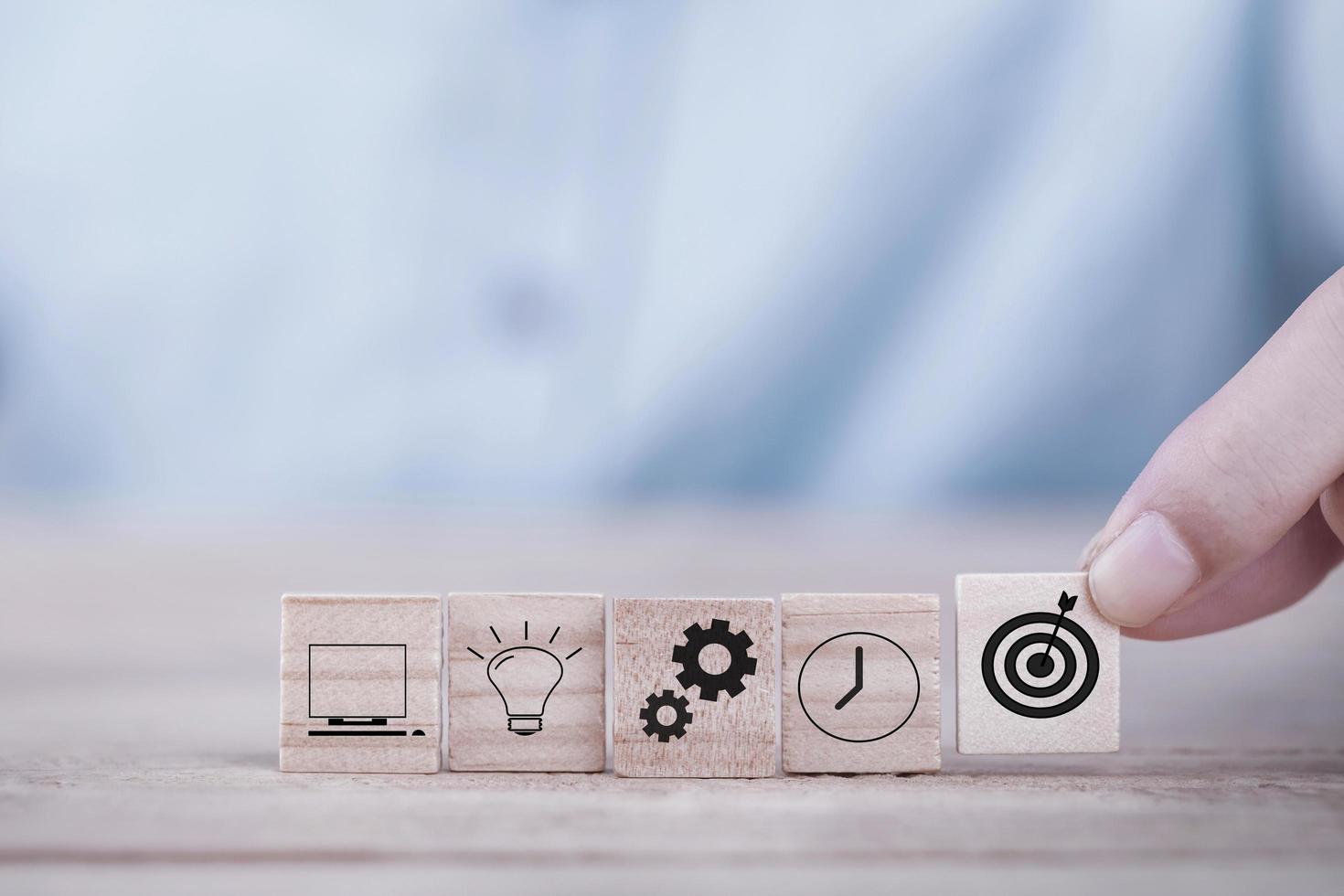 Businessman chooses a emoticon icons target with arrow symbol on wooden block , business strategy and action plan concept photo