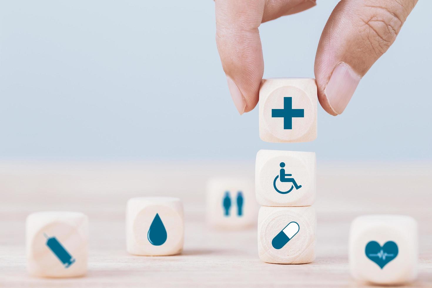 Hand chooses a emoticon icons healthcare medical symbol on wooden block , Healthcare and medical Insurance concept photo