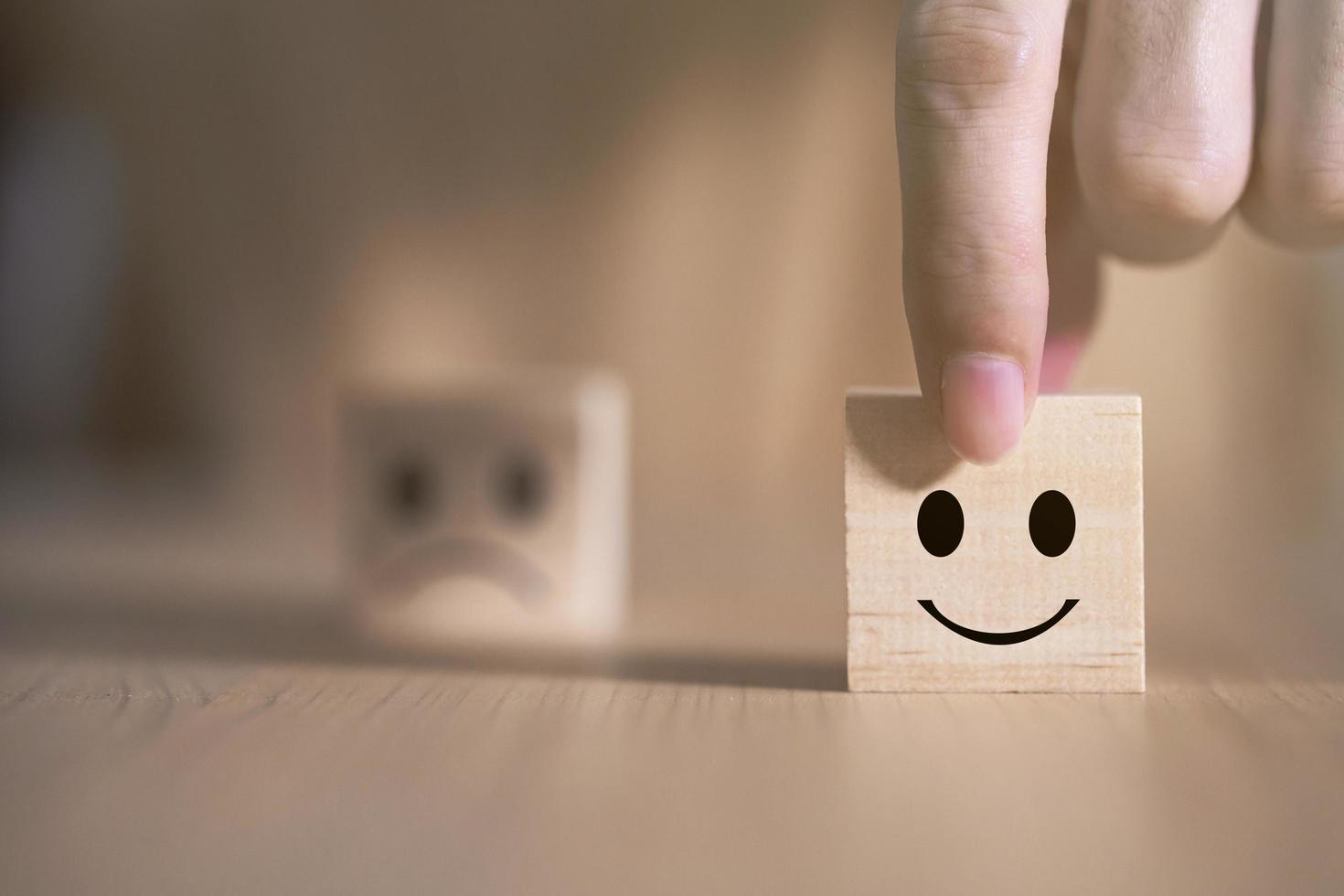 Businessman chooses a smile emoticon icons face happy symbol on wooden block , Services and Customer satisfaction survey concept photo