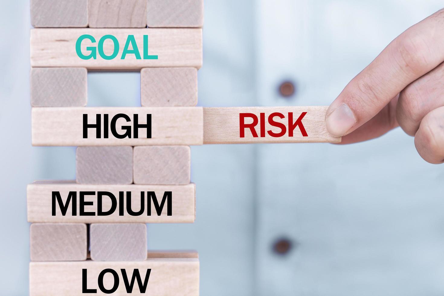 Hand holding chooses wooden block cubes with risk word. Risk management concept. photo