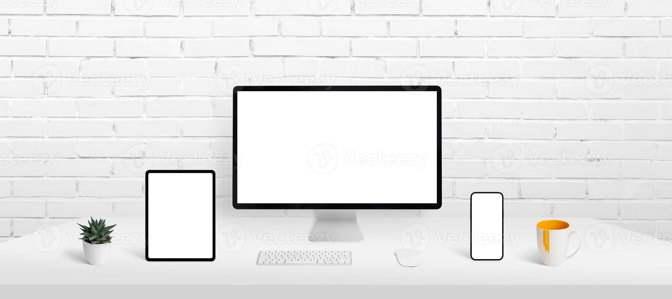 los dispositivos receptivos muestran una maqueta en el escritorio de trabajo. pantalla de computadora, teléfono inteligente y tableta en el escritorio con pantalla aislada para presentación de aplicaciones o páginas web foto