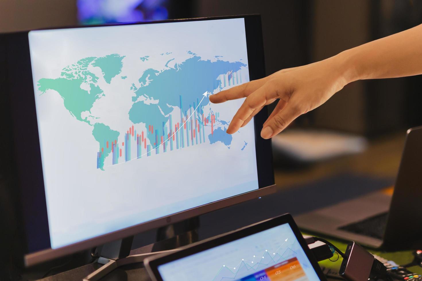 Business financial hand pointing on desktop computer screen with diagram chart photo