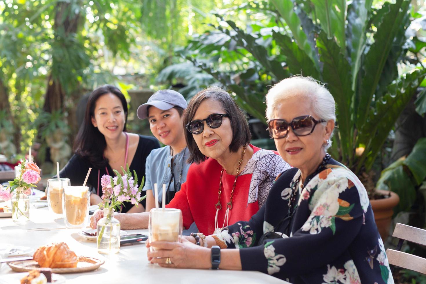 Asian senior woman and adult daughter drinking coffee at cafe outdoor. photo