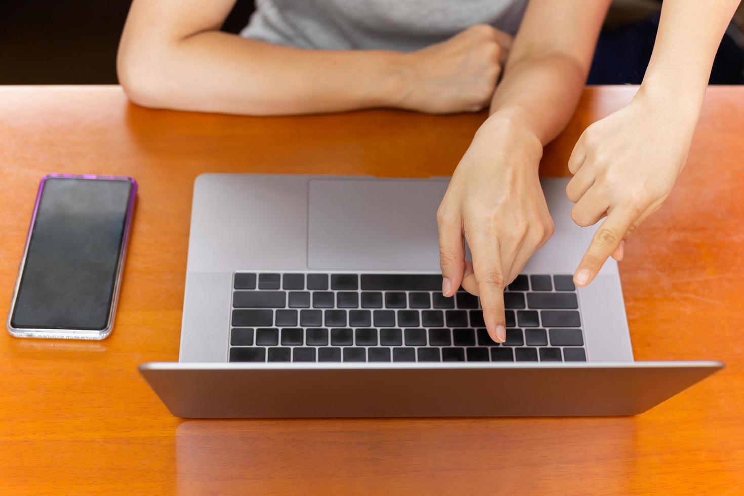 Top view of woman teamwork pointing hand to laptop screen. photo