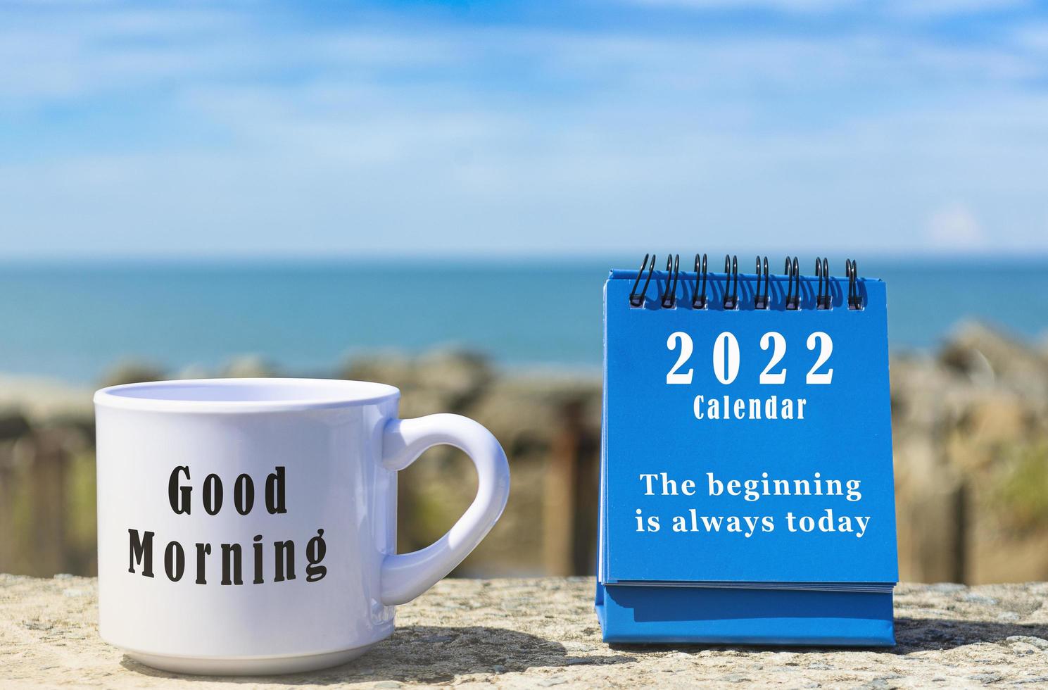 Motivational and Inspirational quote on blue standing notepad and coffee cup photo