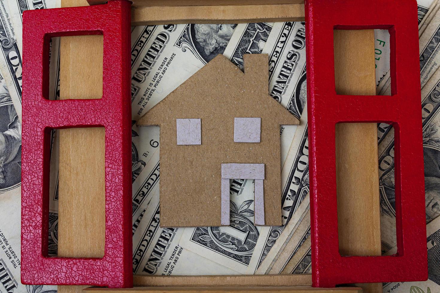 Brown paper house model with window frame on dollar banknotes photo