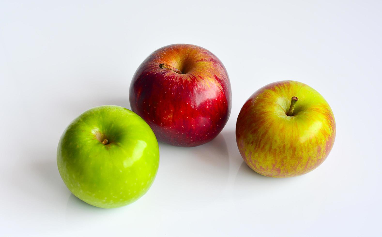 manzanas coloridas, frutas rojas, verdes y amarillas, aisladas en fondo blanco. foto