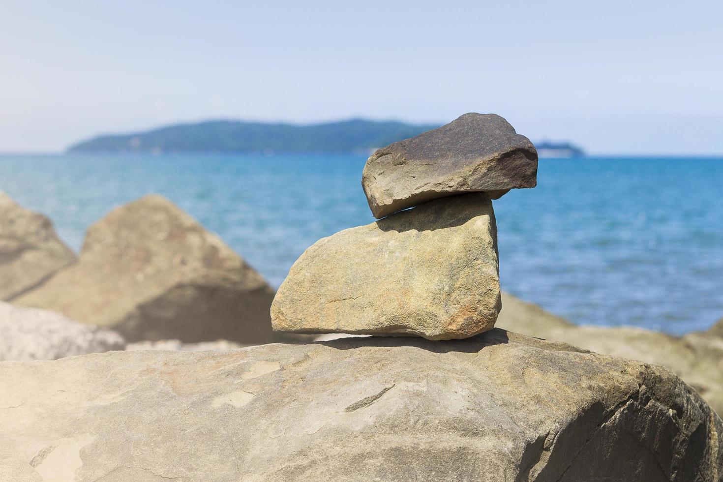 Stones stacked on top of each other with ocean blue photo