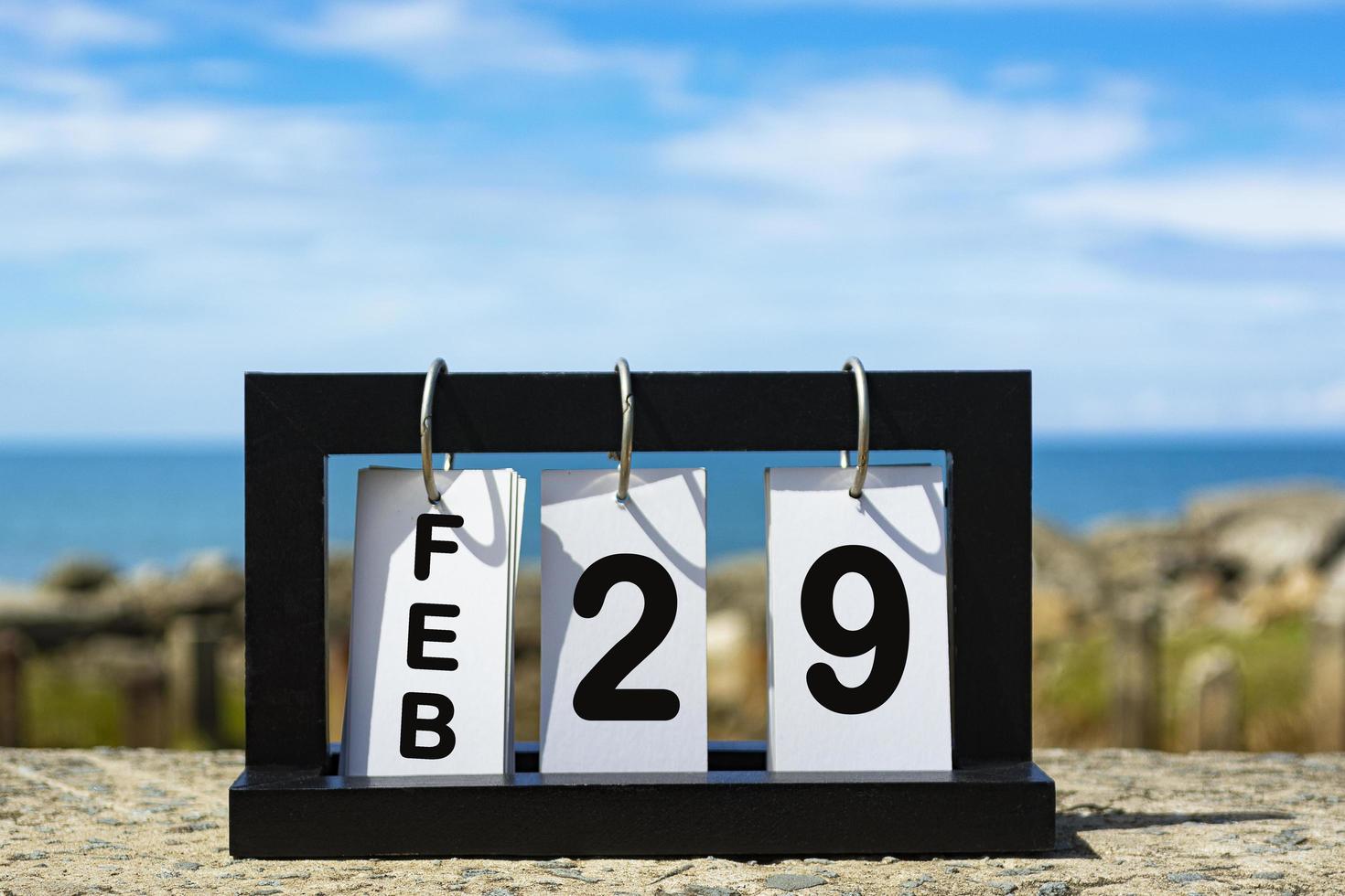 Feb 29 calendar date text on wooden frame with blurred background of ocean photo