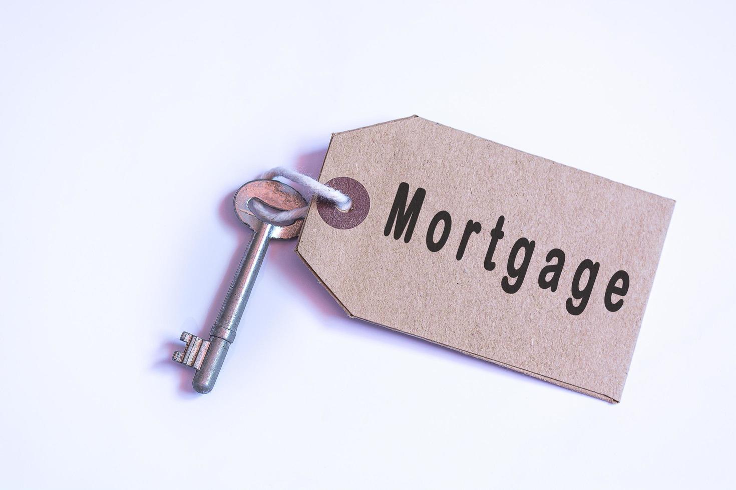 Text on a tag with key on white background. Mortgage concept photo