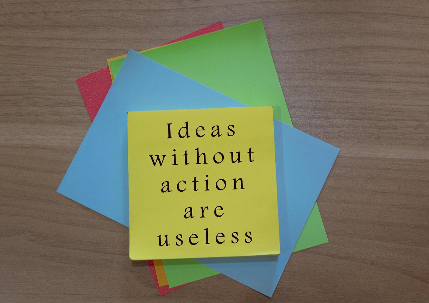 Motivational and inspirational quote on colorful notepad on wooden background photo