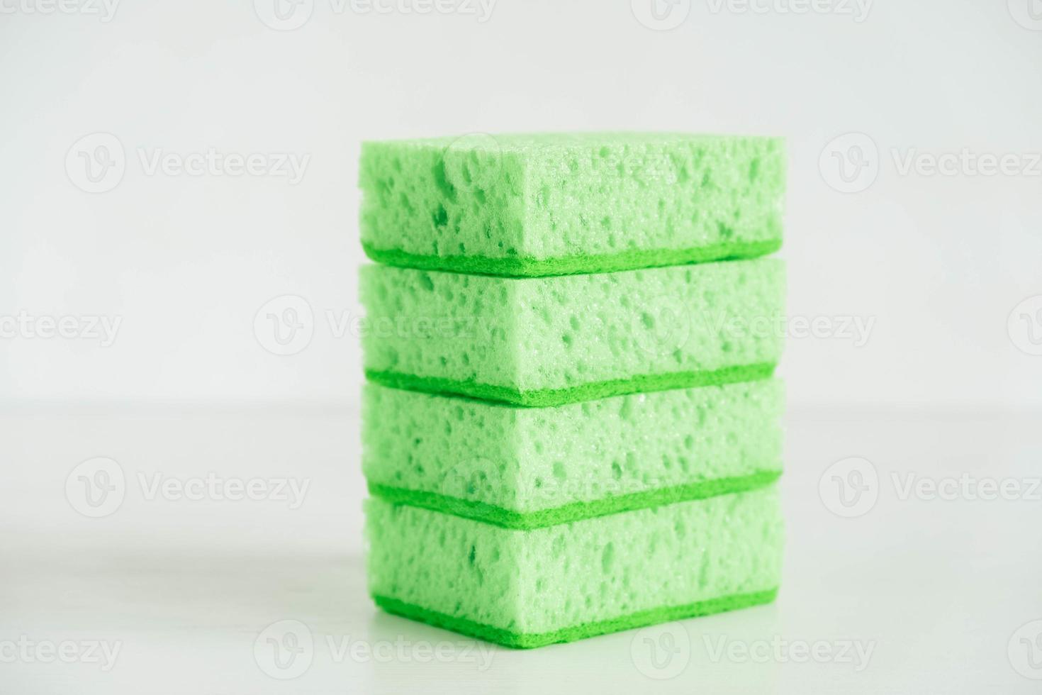 Green sponges for cleaning on a white background photo