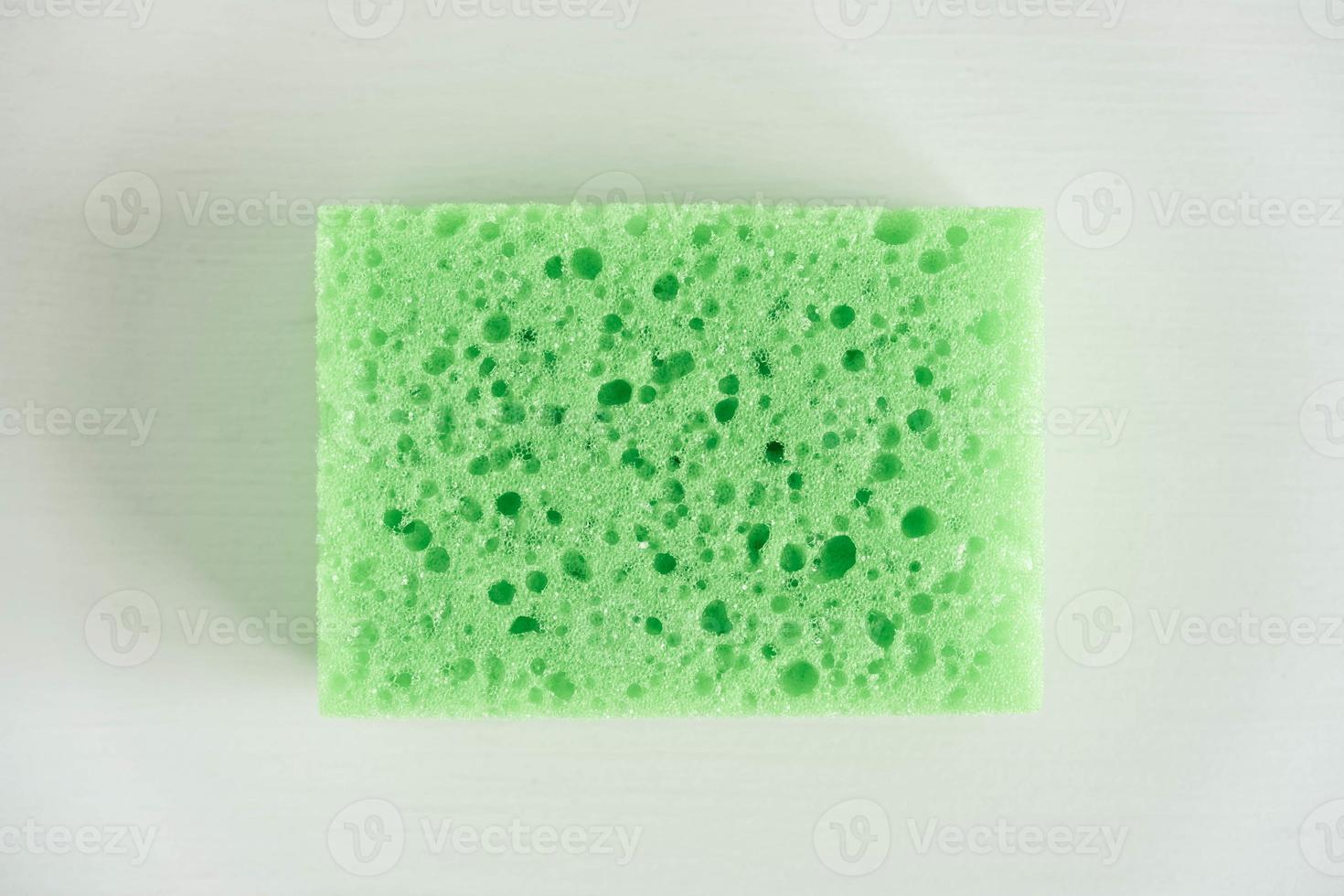 esponja verde para limpiar sobre un fondo blanco foto