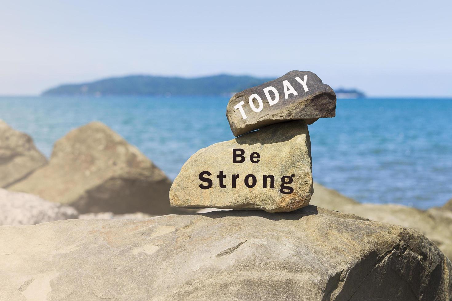 Inspirational text written on stones at the beach with sea view photo