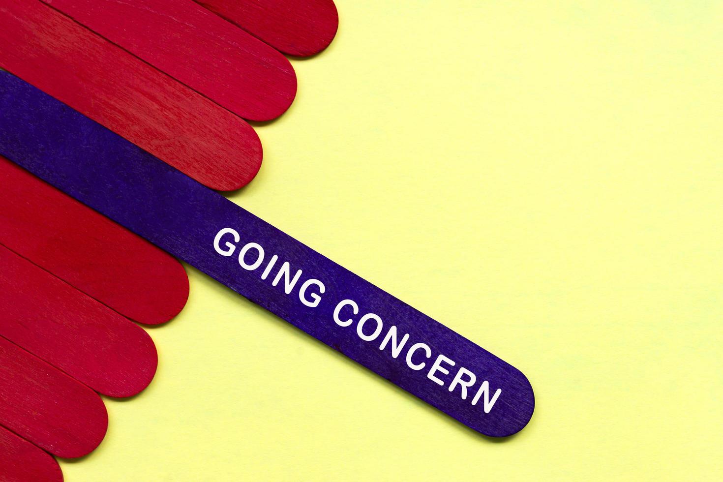 Going concern text on purple color wooden stick. Accounting concept. photo