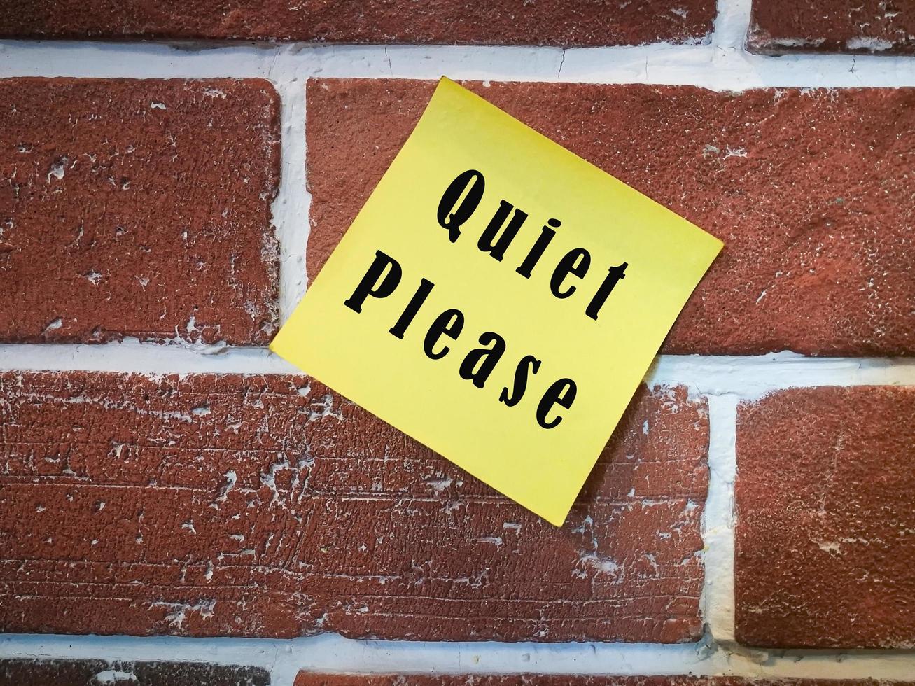 Text on sticky yellow note on brick wall. Quiet please photo