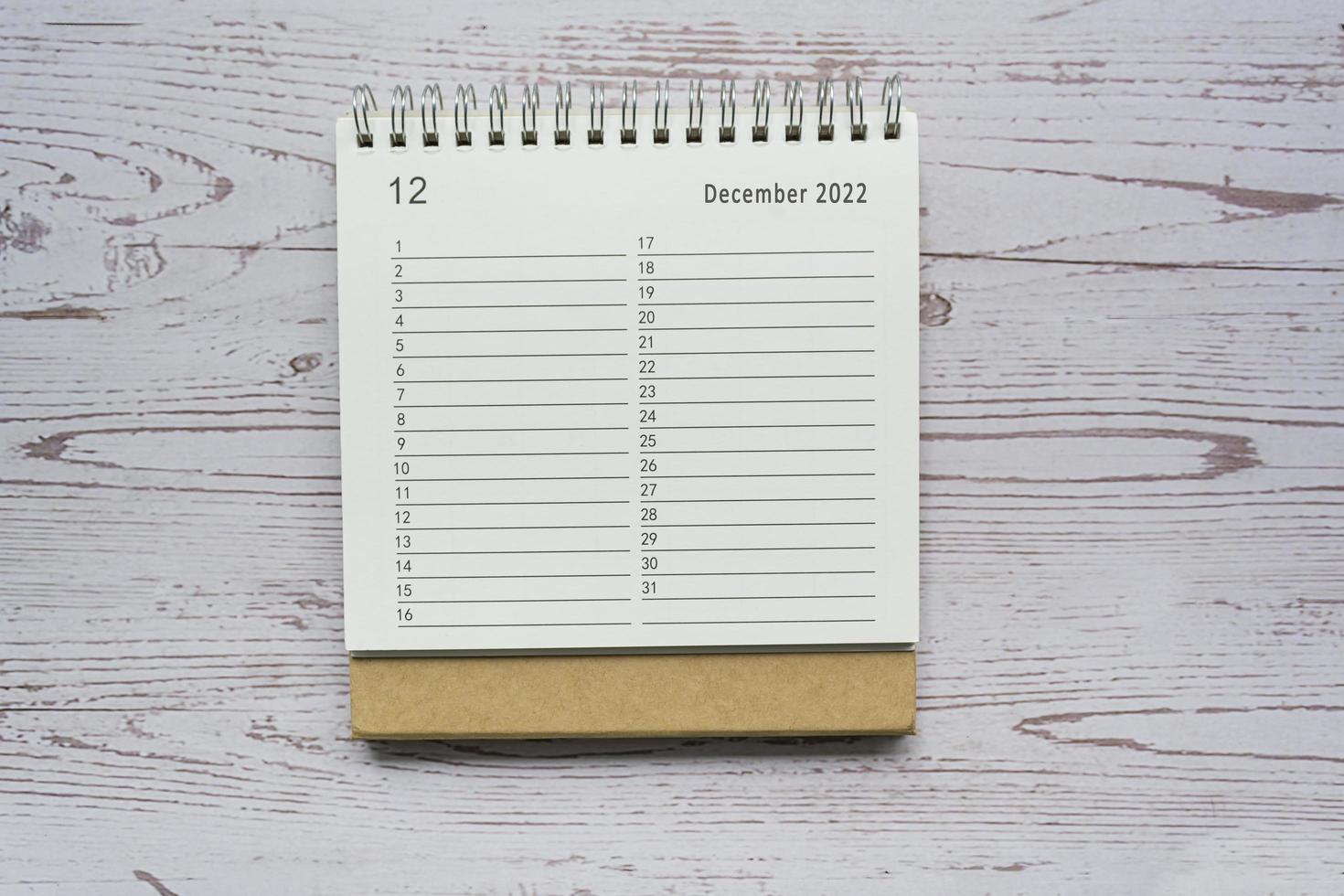 December planner and organizer 2022 calendar on wooden desk. Directly above. photo